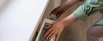 Frau dreht Heizung auf