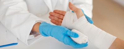 Ärztin verbindet Hand