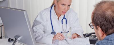 Ärztin mit Stethoskop spricht mit Patienten