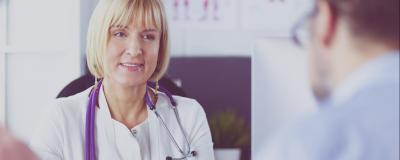Ärztin mit Stethoskop spricht mit Patienten