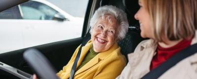 Frau fährt Seniorin zum Arzt