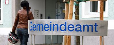 Frau und Gemeindeamt-Schild