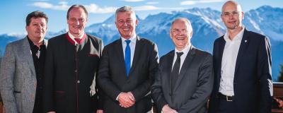 Politiker stehen vor Bergspitzen