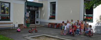 Kinder in einer Gruppe vor einem Kindergarten