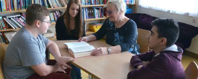 Ältere Frau und Kinder bei einem Buch