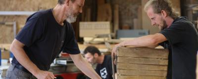 Zwei Männer bei der Arbeit mit Holz