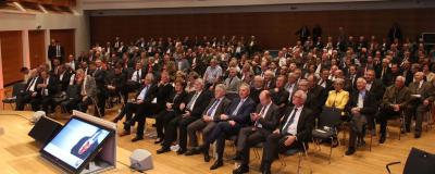 Kommunalpolitiker sitzen in großem Saal
