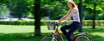 Blonde Dame auf dem Fahrrad im Stadtpark