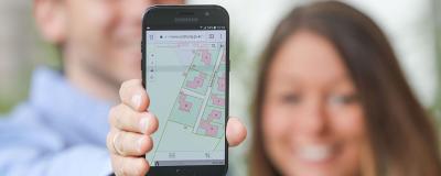 Frau zeigt Landkarte auf Smartphone