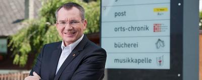 Referent für Gemeinden Tratter vor Schild