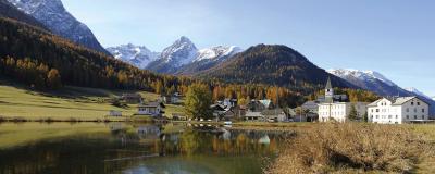 See, Dorf und verschneite Bergspitzen