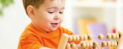 Kind spielt mit Rechenschieber