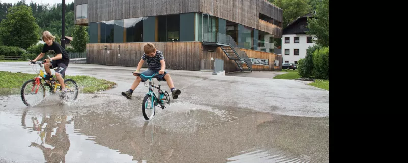 Hinterstoder - Kinder mit Fahrrädern im Regen
