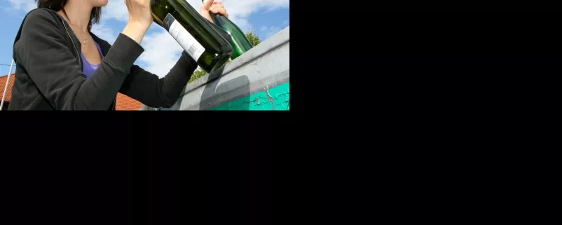 Frau entsorgt Glasflaschen