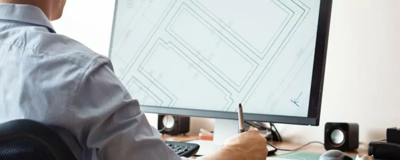 Gemeindemitarbeiter sitzt vor PC Bildschirm