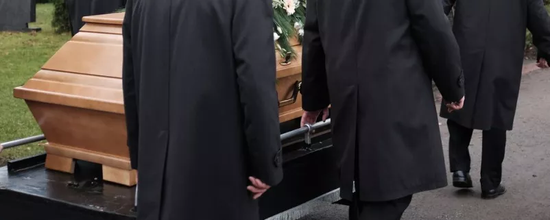 Sarg wird in Gemeinde zu Grabe getragen