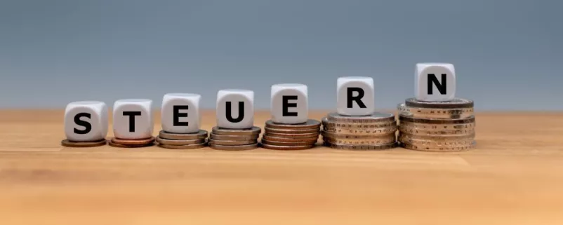 Symbolbild Steuerreform auf Euromünzen mit Würfeln