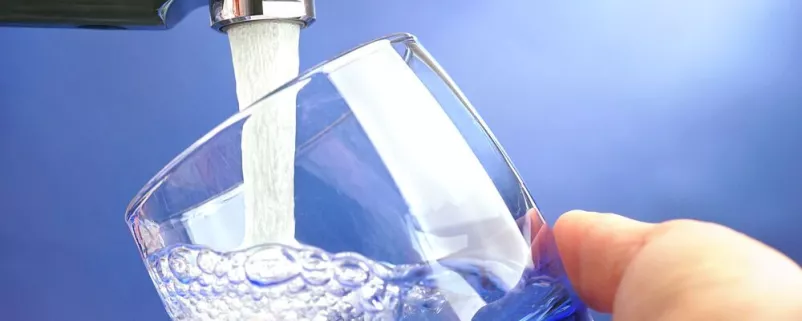 Glas wird mit Wasser aus der Leitung befüllt