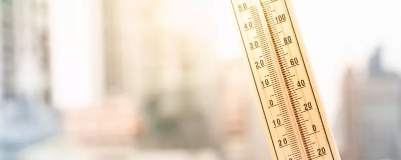 Thermometer vor Großstadt-Hintergrund
