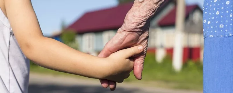 Kind und alte Frau geben einander die Hände