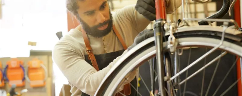 Mann repariert ein Fahrrad - Beispiel Suffizienz