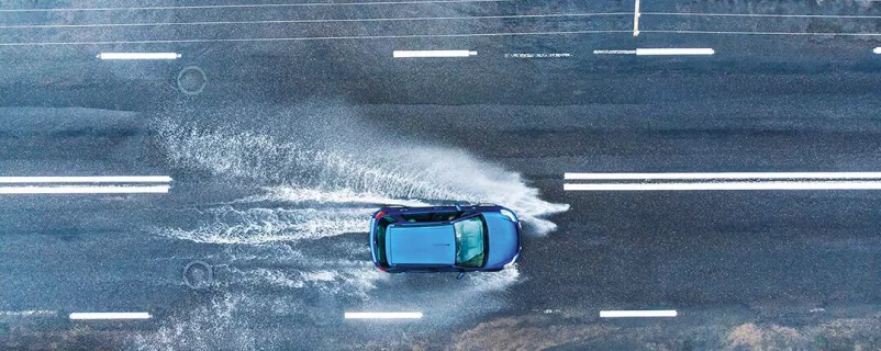 Blaues Auto auf nasser Straße
