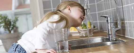 Junges Mädchen unter dem Wasserhahn
