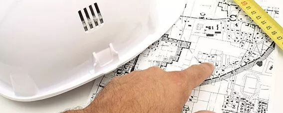 Hand deutetet auf einen Bauplan