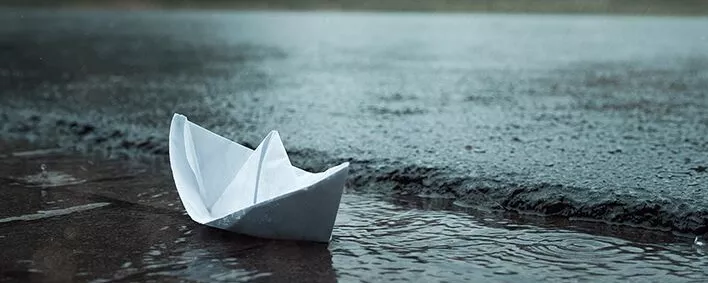 Papierschiff im Rinnstein