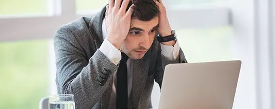 Mann verzweifelt vor Laptop