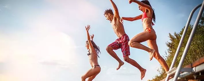 Junge Leute springen in einen See