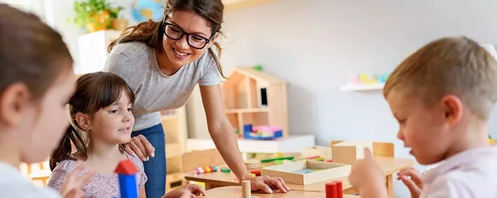 Kinder und Betreuerin im Kindergarten