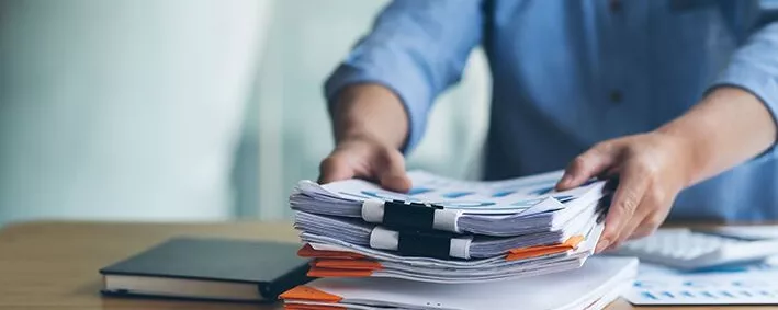 Mann legt Papierstapel ab
