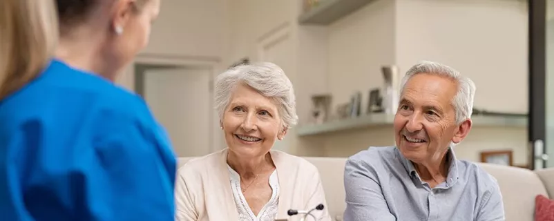 Community Nurse berät älteres Paar.