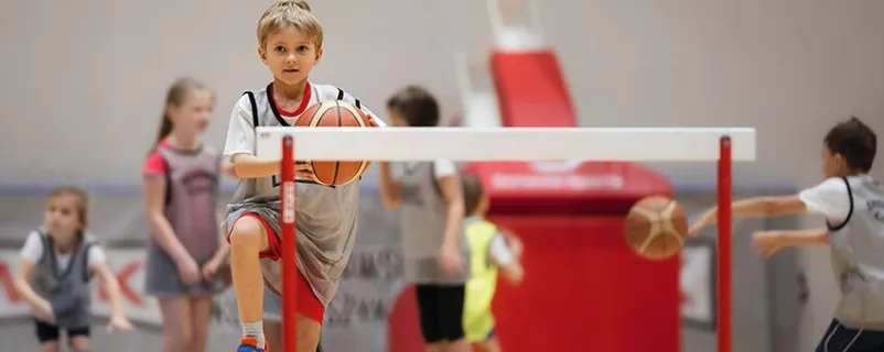 Bub turnt mit Basketball in der Hand