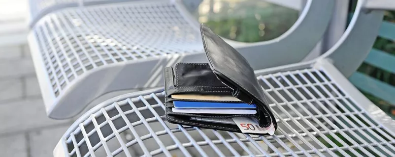 Verlorener Geldbeutel liegt auf einer Bank