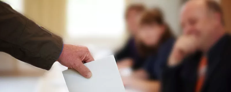 Wahlkuvert wird eingeworfen