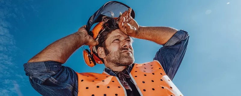 Arbeiter in Sicherheitskleidung schwitzt in der Sonne
