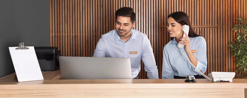 Mann und Frau an einer Hotelrezeption