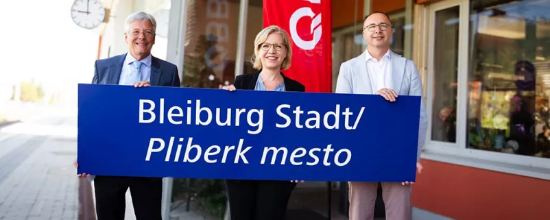 Kärntens Landeshauptmann Peter Kaiser, Ministerin Leonore Gewessler und ÖBB-Infrastruktur-Vorstand mit der neuen Stationstafel in St. Michael ob Bleiburg / Šmihel pri Pliberku