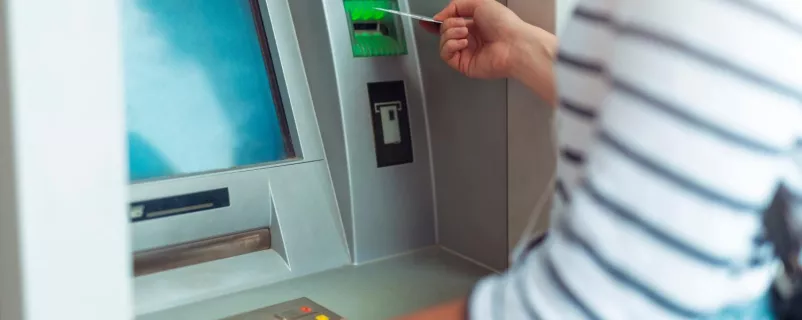 Frau behebt Geld von einem Bankomat
