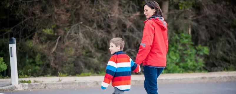 Mutter und Sohn überqueren Strasse