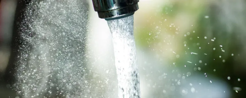 Wasser rinnt aus Hahn