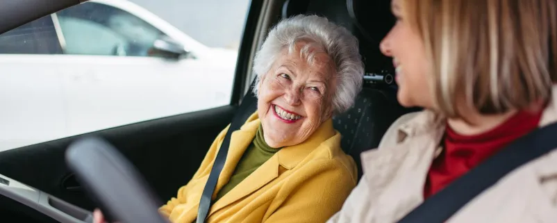 Frau fährt Seniorin zum Arzt