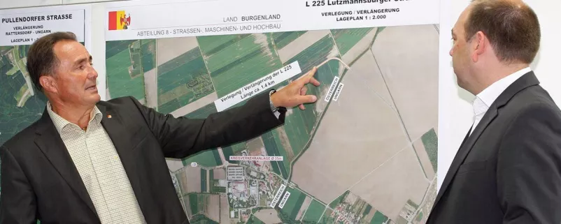 Bieler und Heckenast vor einer Landkarte für die Baupläne