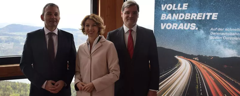 Politiker vor Plakat zum Breitbandausbau