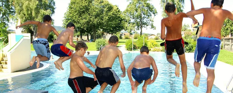 Kinder springen gemeinsam in einen Pool