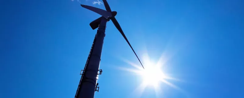 Windrad wird von unten, gegen die Sonne, gezeigt