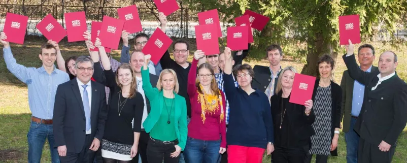 Gemeindemitarbeiter halten Diploma hoch