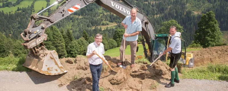 Kommunalpolitiker mit Schaufeln und Bagger